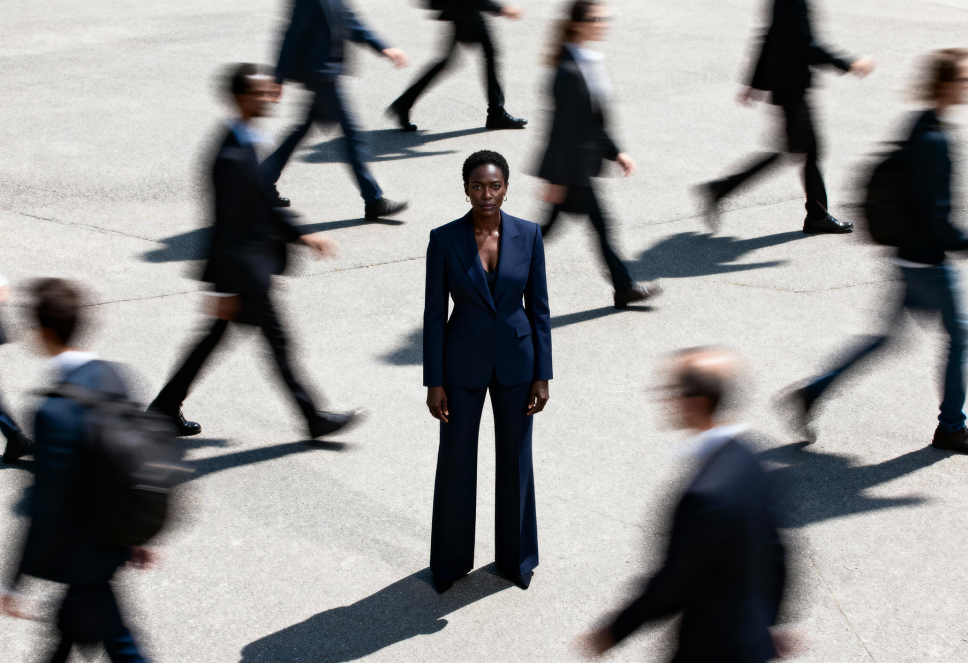 A person standing still while a blurred crowd moves past them